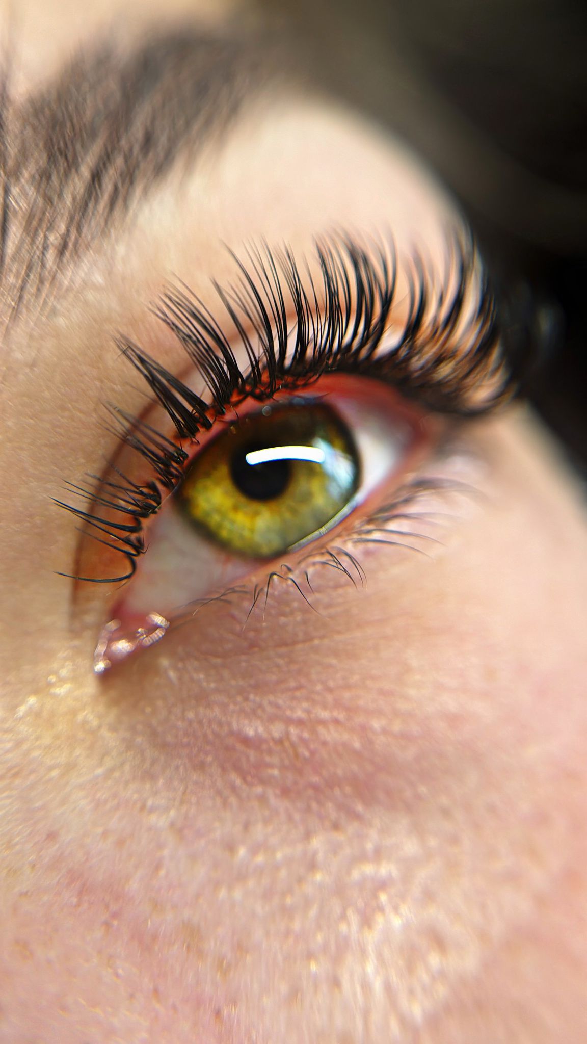 Close-up of lash extensions with green eye